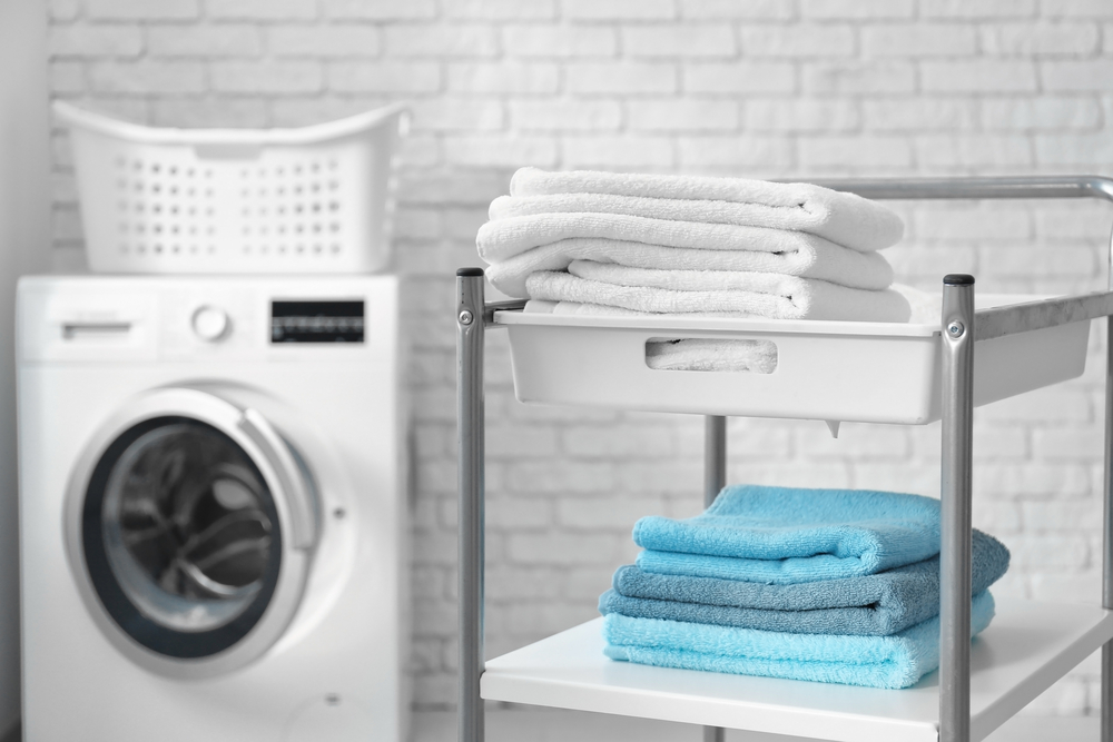 Stack of clean towels on cart in laundromat ניקוי יבש בתל אביב
